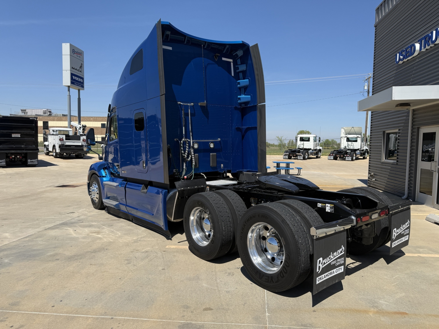 Peterbilt 579 tractor in blue, side and rear view showing sleeper cab, dual rear axles, chrome wheels, and mudflaps with Br0nkston logo.