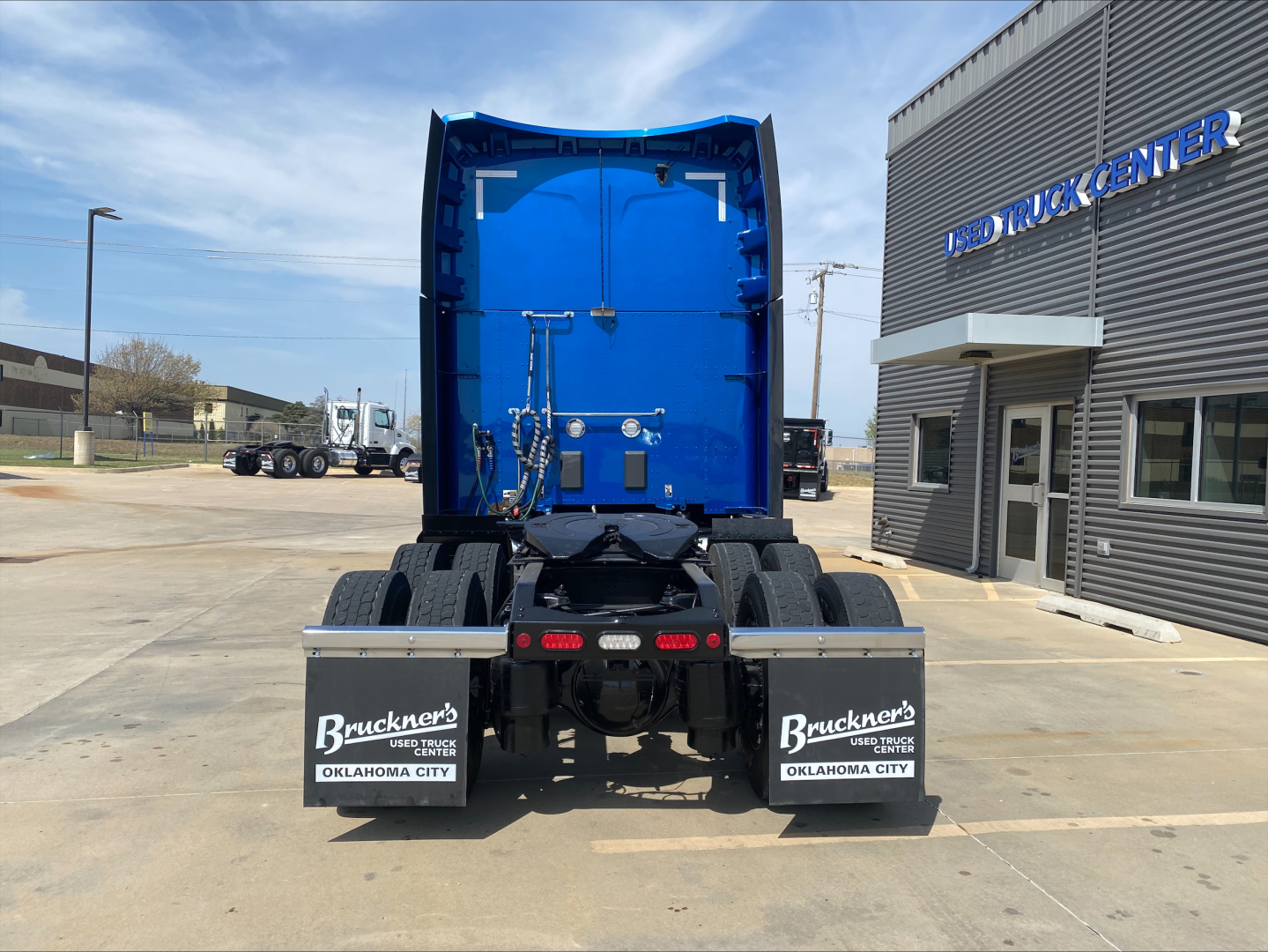 Peterbilt 579 rear view showing blue cab and dual rear mudflaps with Buckner brand, Oklahoma City, at dealership.