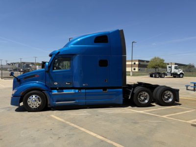 Peterbilt 579 tractor in blue side view showing sleeper cab and dual rear axles.