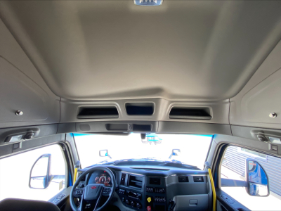 Peterbilt 579 cab interior dashboard and overhead area visible with steering wheel, gauges, and controls in view.