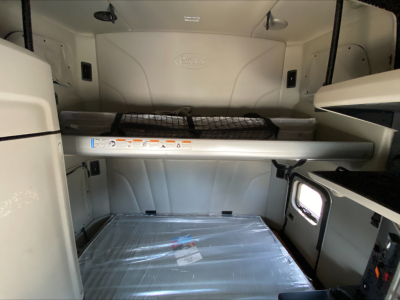 Peterbilt 579 sleeper cab interior showing storage bunk, upper toolbox, and cargo platform.
