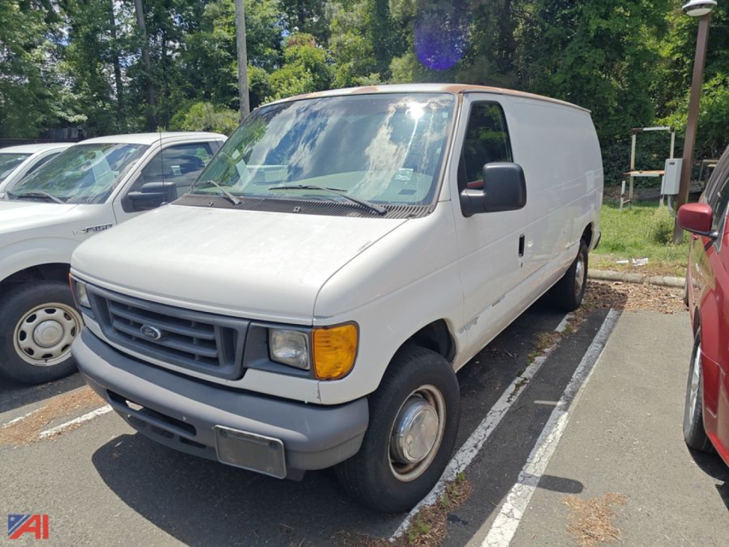 Ford E-Series cargo van in a parking lot, front-left view, white exterior, grey bumper, black side mirrors
