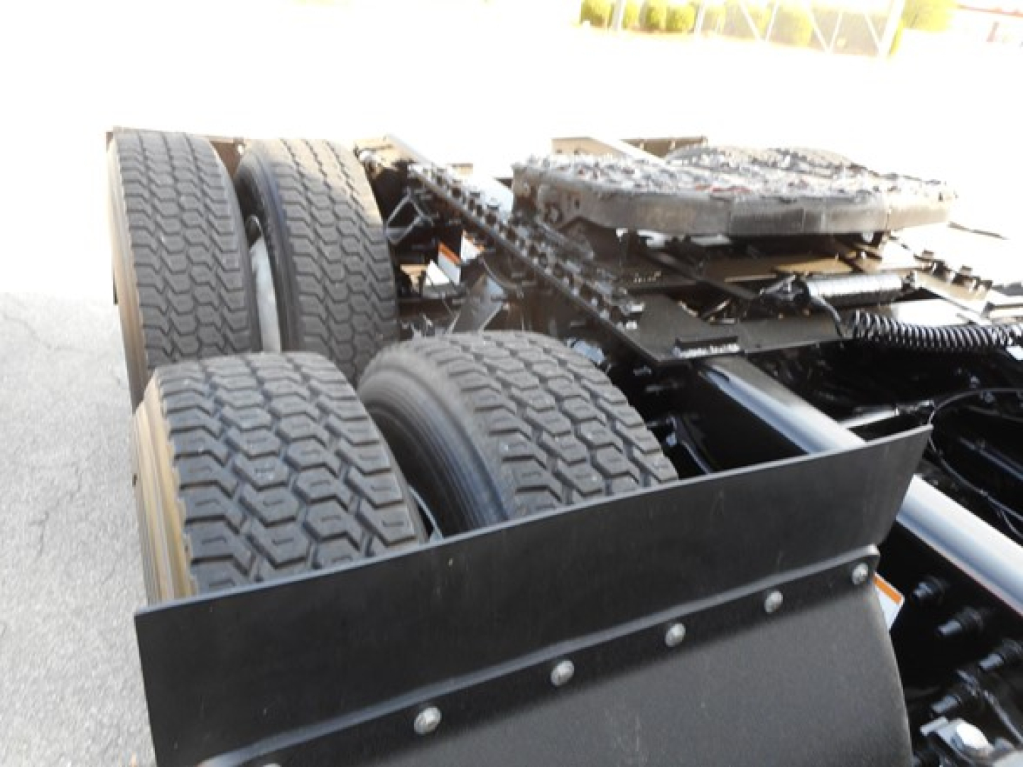 Freightliner Cascadia truck chassis showing dual rear axles and heavy-duty tires, view of undercarriage and frame rails.