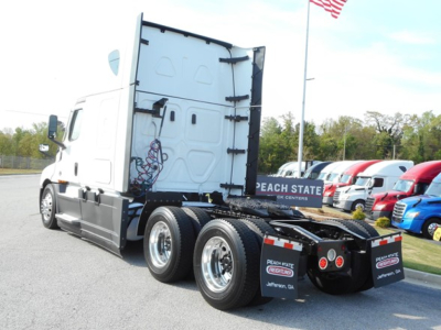 Freightliner Cascadia 126 tractor rear view showing dual rear axles and fifth wheel in a truck lot.