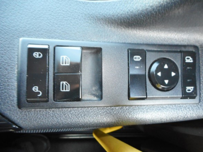 Truck interior control panel showing window and mirror adjustment switches in a Freightliner Cascadia cabin.
