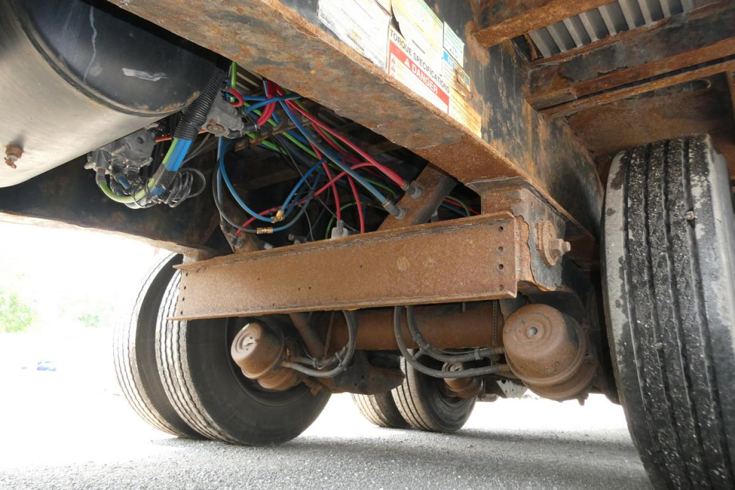 Chassis undercarriage showing leaf spring suspension and electrical wires on a Fontaine trailer.