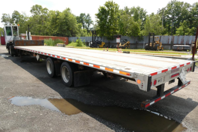 Trailer deck showing a Fontaine HCITX22RSA drop deck trailer with dual rear axles and reflective tape