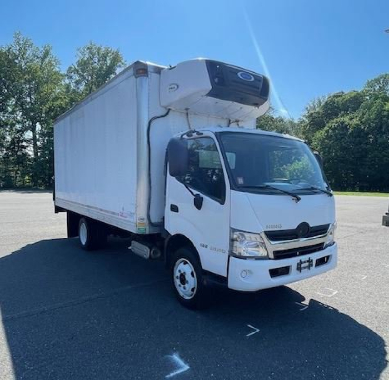 Box truck with a white cab and a refrigerated box, cooling unit mounted on the front of the box roof. Side mirrors, headlights, and logo visible on cab.