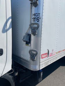 Rear corner of a 2020 Hino 195 box truck showing cargo area with HGT 11'6" markings and door latches.