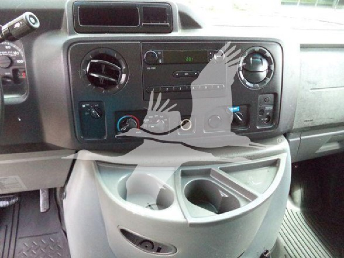 Dashboard of a 2011 Ford E450 utility truck showing center console with radio, climate controls, air vents, and cup holders.