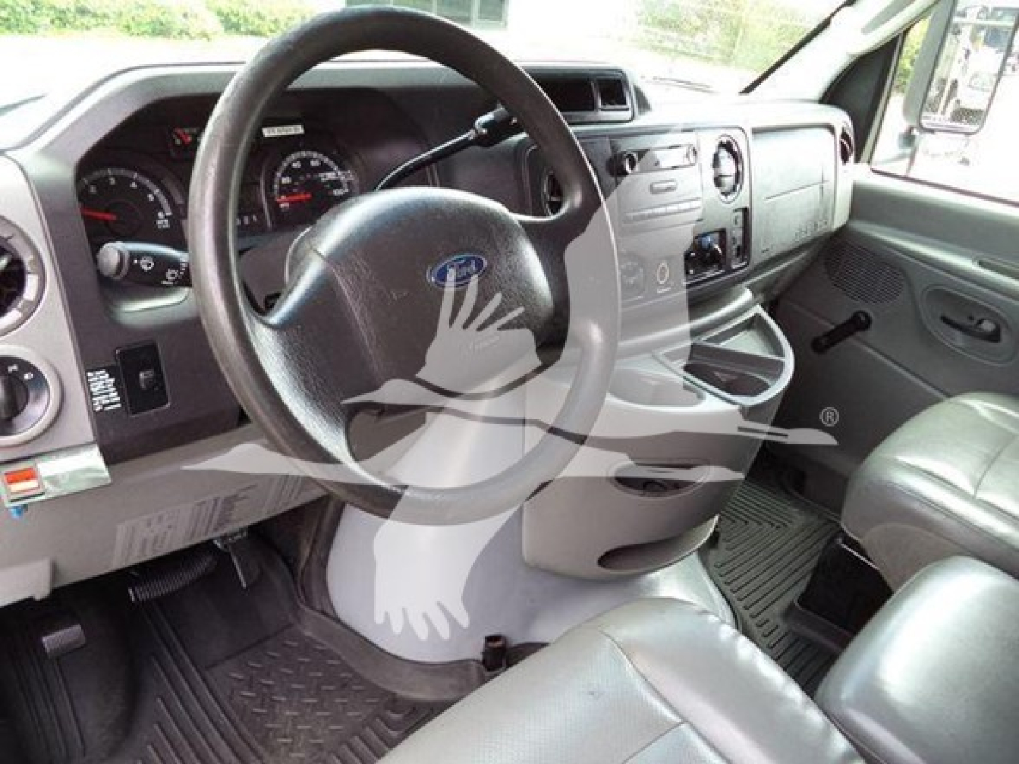 Ford E-450 interior with steering wheel and dashboard view, showing gray seats and center console.