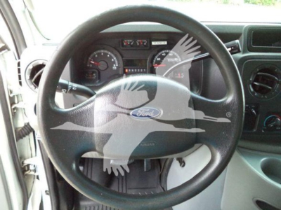 Ford E-450 van interior showing steering wheel with Ford logo, dashboard gauges, and steering column.