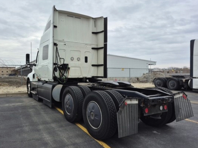 Truck cab and rear chassis of a used 2023 International LT625 tractor, side view showing dual rear axles, fifth-wheel area, and mud flaps.