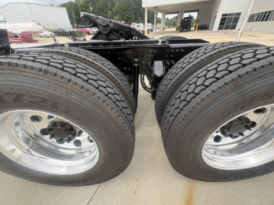 Mack PI64T tractor truck rear dual tires and undercarriage showing frame, axles, and exhaust components.