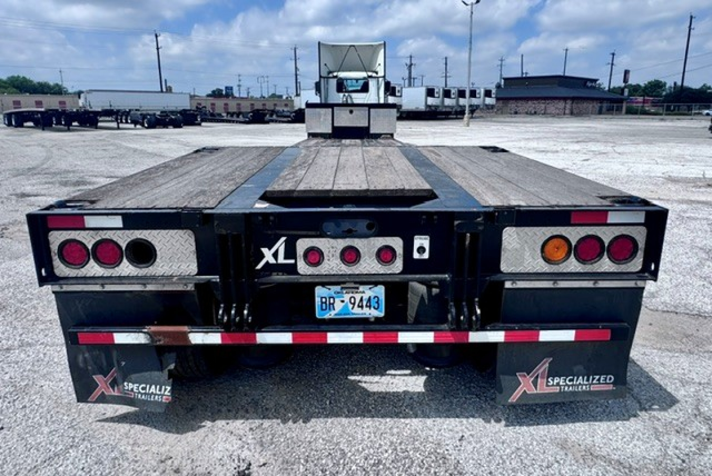 Trailer rear view showing flatbed XL Specialized XL 80 MDE with dual rear lights, license plate BR-9443, and branding XL Specialized Trailer decals.
