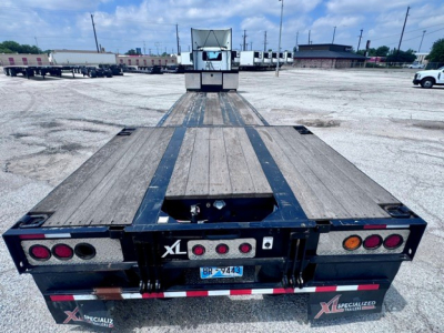 Trailer bed of a 2023 XL Specialized XL 80 MDE lowboy trailer showing steel deck, rear ramps, taillights, and branding. VIN 4U3J04820PL021916 and stock B3473 visible.