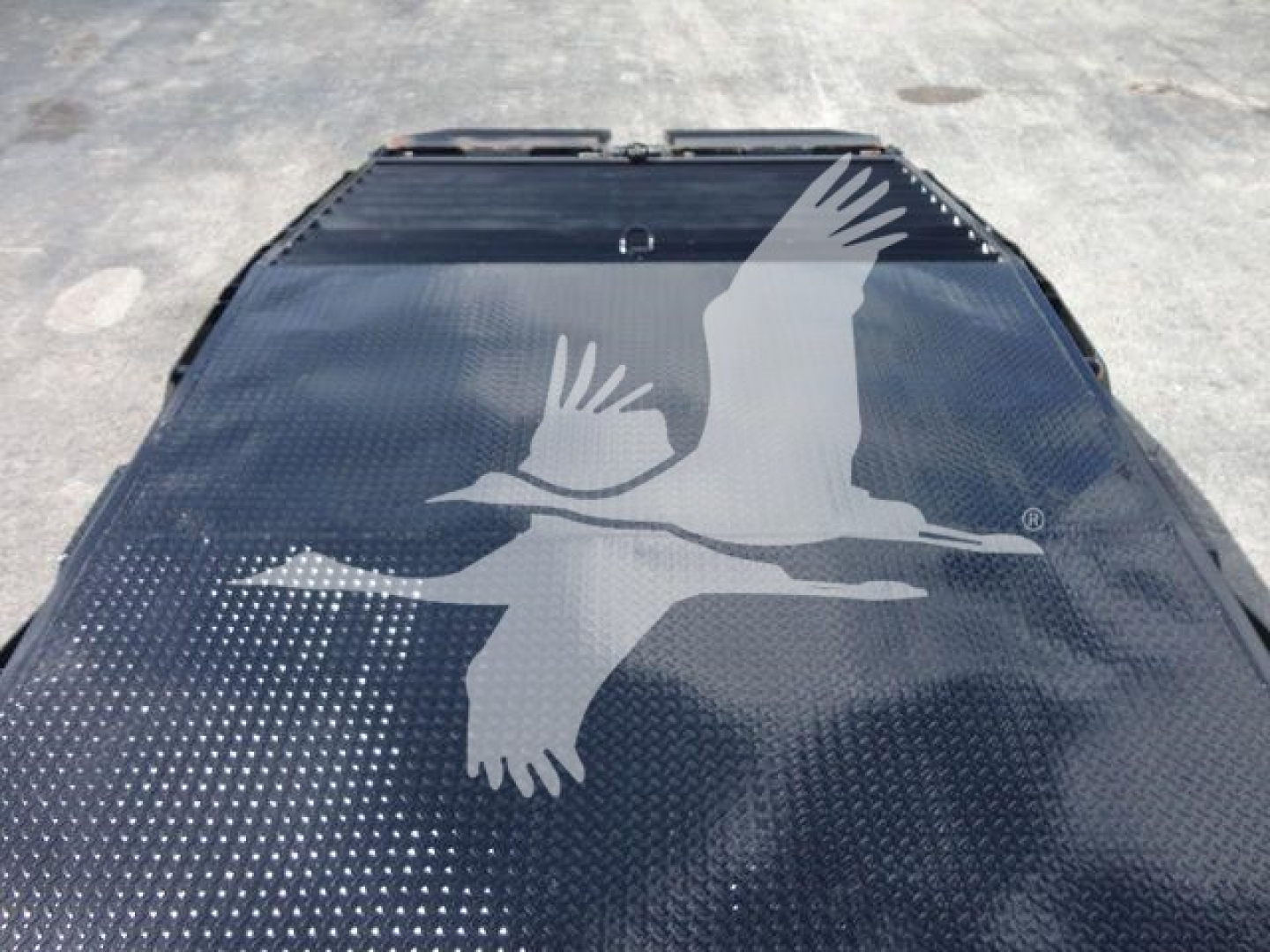 Flatbed image of a 2027 Freightliner Business Class M2 rollback truck cover with a large white bird decal on a dark diamond plate surface.