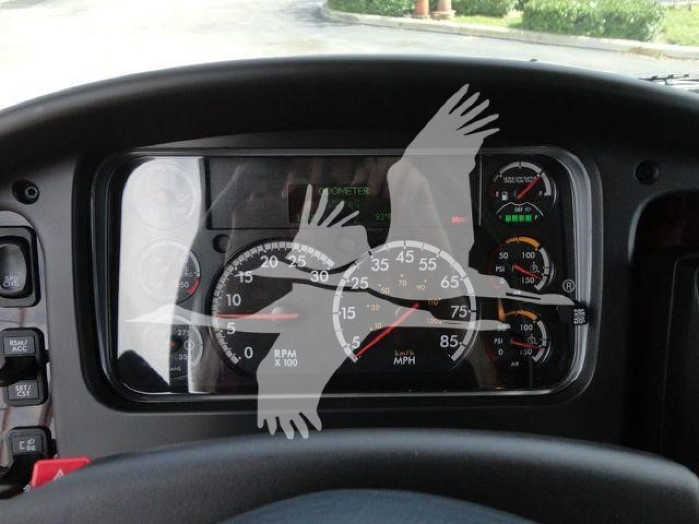 Dashboard view of a Freightliner Business Class M2 instrument cluster with speedometer, RPM gauge, and warning lights.