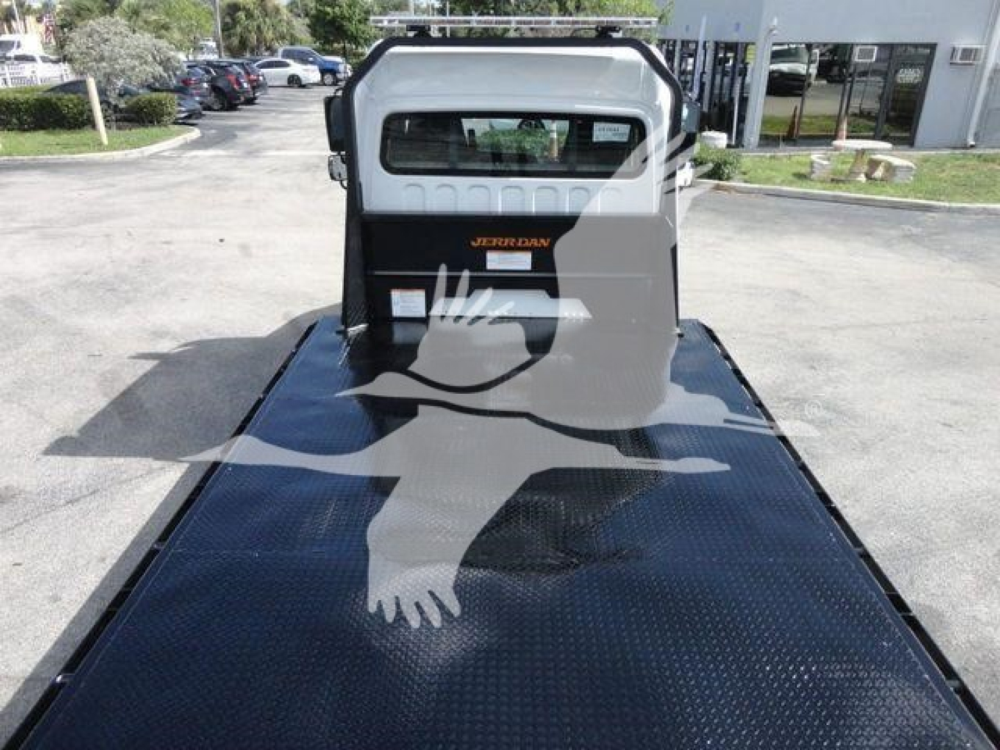 Diesel truck bed of a 2027 Freightliner Business Class M2 rollback chassis with a Jordan branding on the cab rear window and a diamond-plate flatbed.