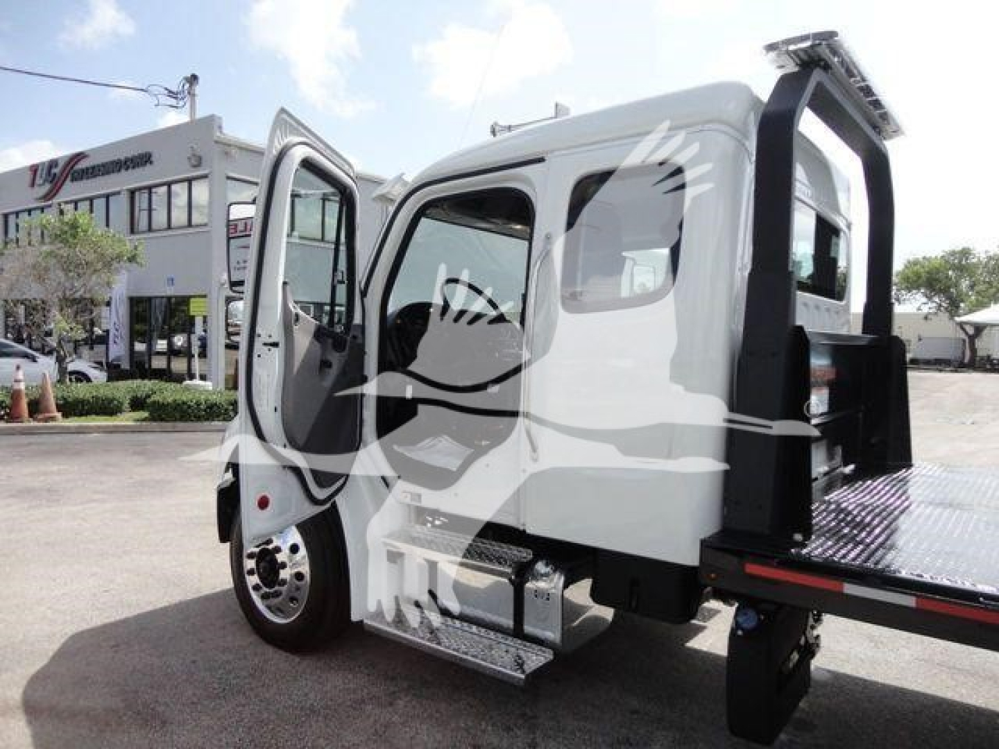 Freightliner Business Class M2 rollback truck with open door and flatbed section, side view showing cab and entry steps.
