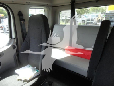 Interior of a 2027 Freightliner Business Class M2 cab with two seats, a bench seat in the back, and seat belts visible; includes a red tool box and scattered documents.