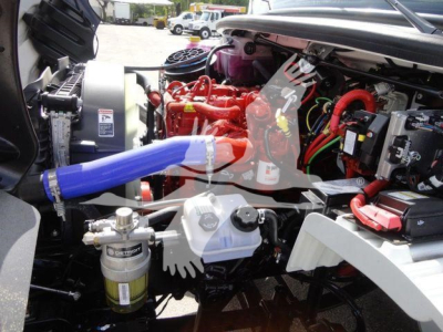 Truck engine bay with red engine block, various hoses, and blue radiator hose visible; components and wiring in view.