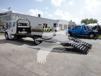 Freightliner Business Class M2 rollback truck with a tow bed and ramp, blue pickup in background, stock number DOVETAILM2.