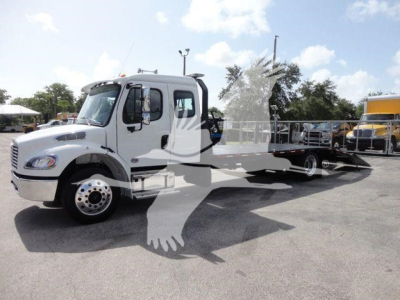 White Freightliner business class M2 rollback tow truck with flatbed, side view showing cab, wheels, and equipment; watermark present.