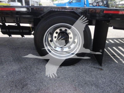 Wheel and rear section of a Freightliner Business Class M2 rollback truck showing chrome wheel and black chassis with mud flap.