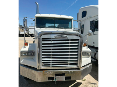 Front view of a Freightliner FLD120 daycab truck showing chrome grille, rectangular headlights, and large front bumper.
