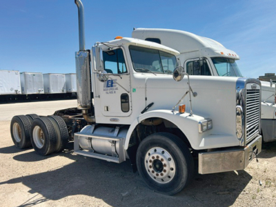 Freightliner FLD120 truck side/front view showing cab and chassis with dual rear axles and chrome exhaust stack.