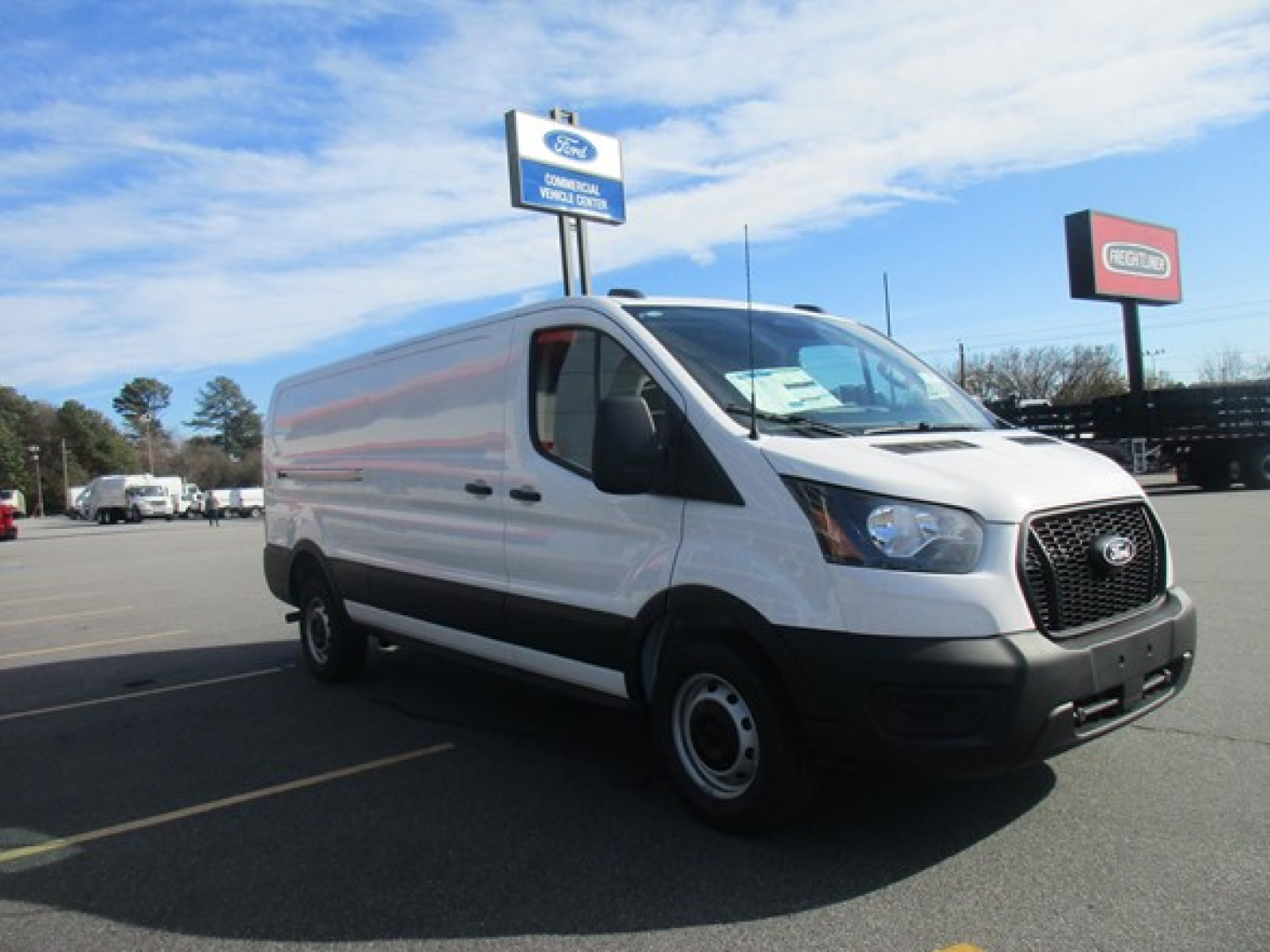 Ford Transit cargo van showing exterior with front grille and side panel; no visible text legible on vehicle
