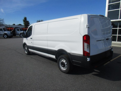 Ford Transit cargo van rear-right view showing solid white body panels, black bumper, and rear doors; no visible branding text legible.
