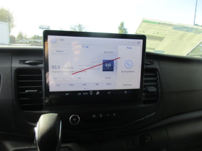 Dashboard of a 2026 Ford Transit cargo van showing a central touchscreen infotainment display with radio and car settings.