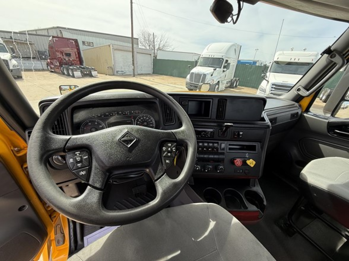 Cab interior of a 2019 International LT625 truck showing steering wheel, dashboard, center console with controls, and instrument cluster.