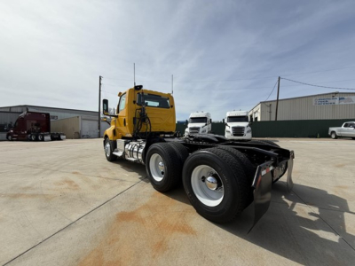 2019 International LT625 truck chassis rear view showing dual rear axles and yellow cab with black chassis in a lot.