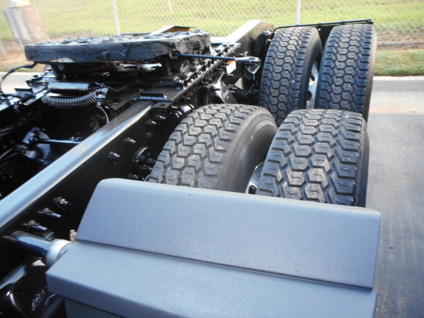 Freightliner Cascadia truck chassis showing rear dual wheels and frame with exposed drivetrain components.