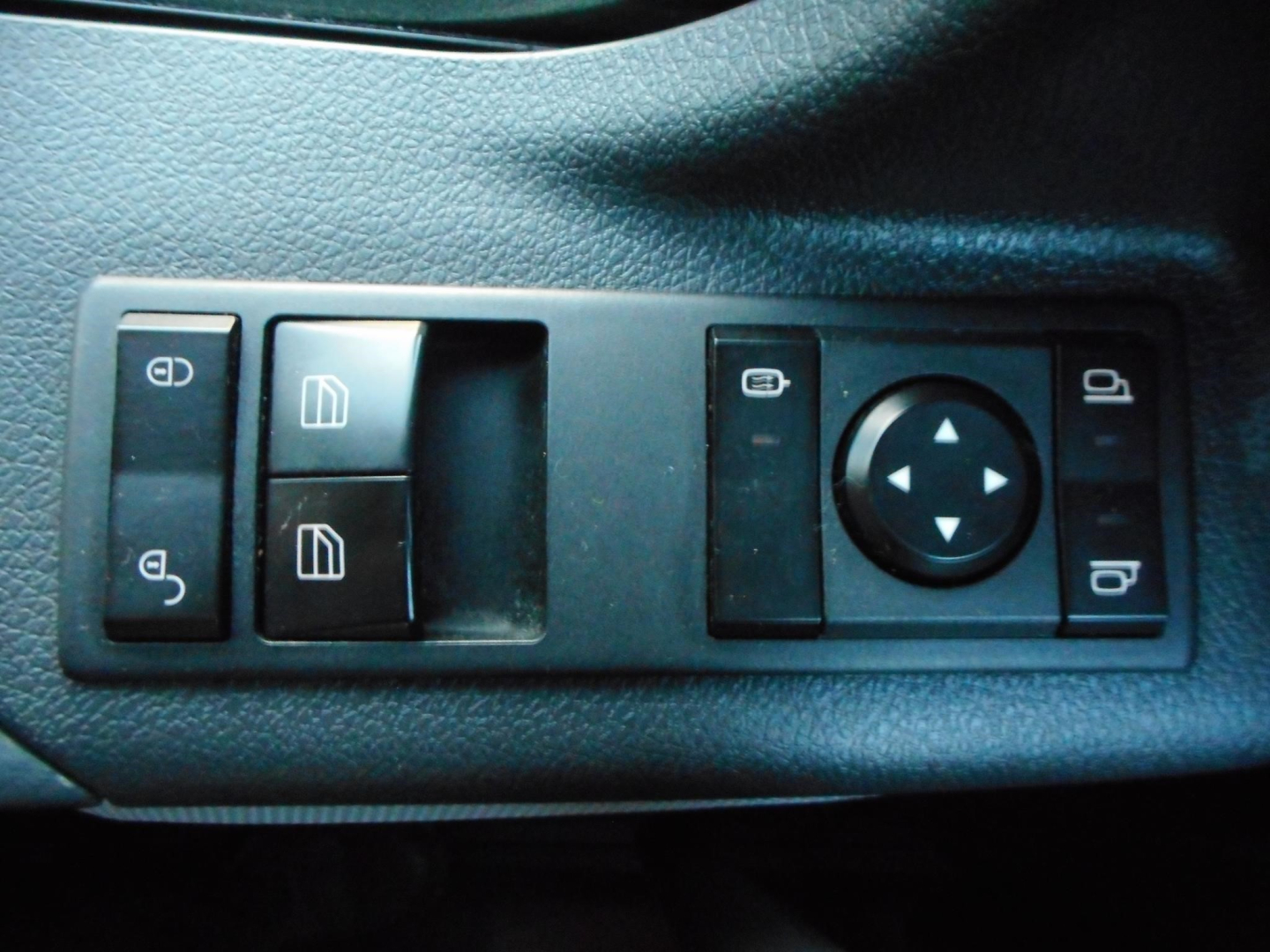 Freightliner Cascadia control panel with window switches, mirror adjust, and lock buttons.