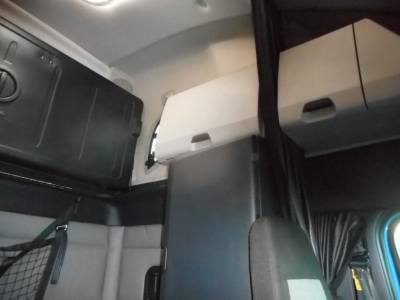 Cab interior of a 2022 Freightliner Cascadia 126 showing overhead storage compartments and sleeper area.