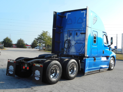 Freightliner Cascadia 126 sleeper tractor rear three-quarter view showing blue exterior and rear dual axles.
