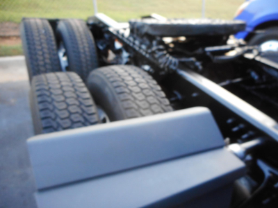 View of a Freightliner Cascadia chassis with rear axles and suspension, showing tires and frame rails.