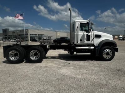Mack GR64F dump truck side view showing chassis and cab with exhaust stack and dual rear axles.