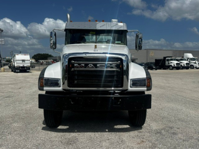 Front view of a white 2027 Mack GR64F dump truck showing grille, headlights, and bumper.