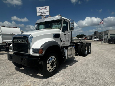 Front-left view of a white 2027 Mack GR64F truck in a dealership lot showing the cab, grille with MACK letters, side mirrors, and front bumper.