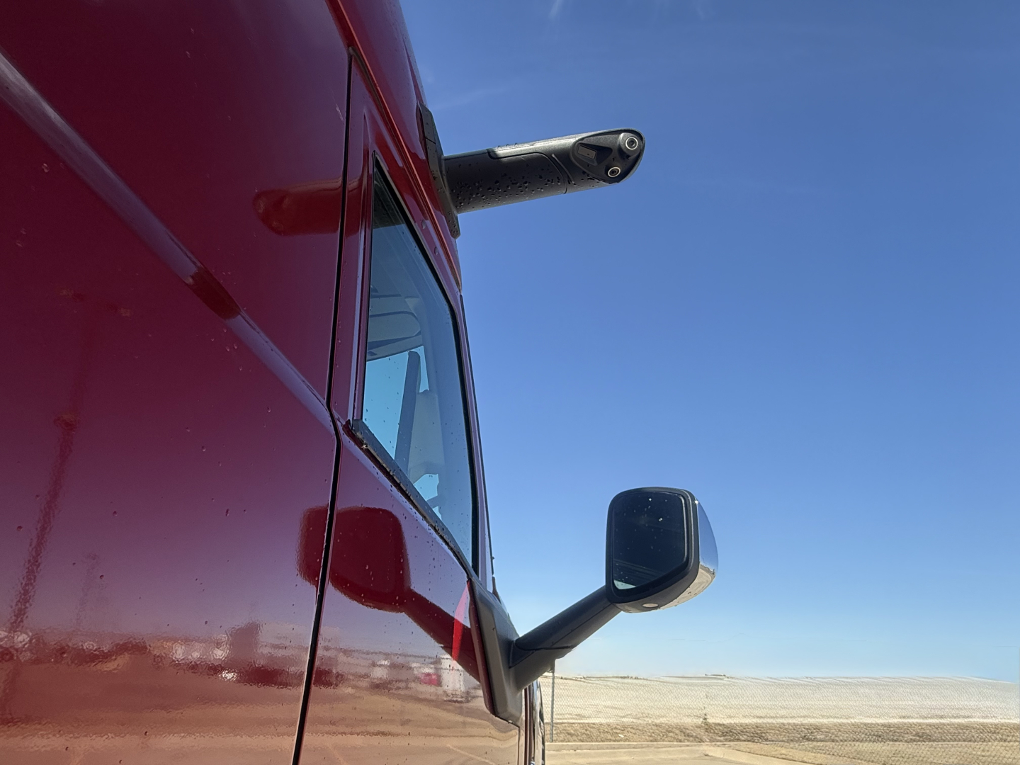 Mack PR64T76H conventional sleeper truck side view mirror and cab corner.