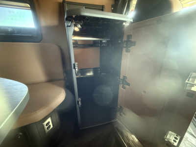 Cabin interior showing open cabinet/locker with shelves and latching doors in a Mack PR64T76H truck.
