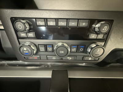 Truck dashboard/control panel with multiple buttons and dials; no legible labels readable due to resolution.