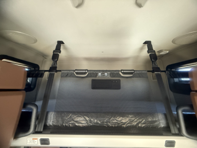 Mack PR64T76H sleeper cab interior showing overhead bunk area with safety straps and storage net.