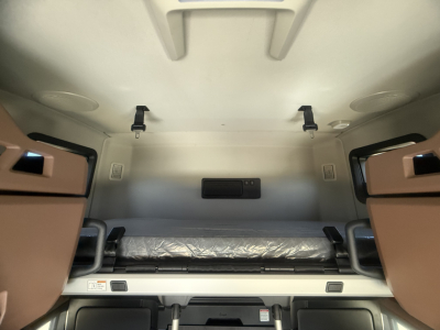 Interior sleeper cab of a Mack PR64T76H truck showing bunk bed area with mattress and side cabinets.