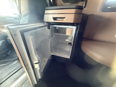 Interior of 2026 Mack PR64T76H cab showcasing compact refrigerator and storage compartments inside a sleeper cab.